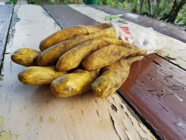 Gartenhandschuhe auf Tisch im Garten